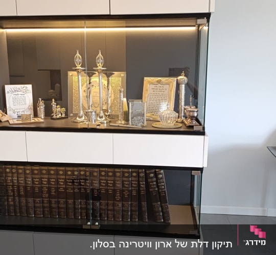 ארון זכוכית עם חפצי נוי וספרים